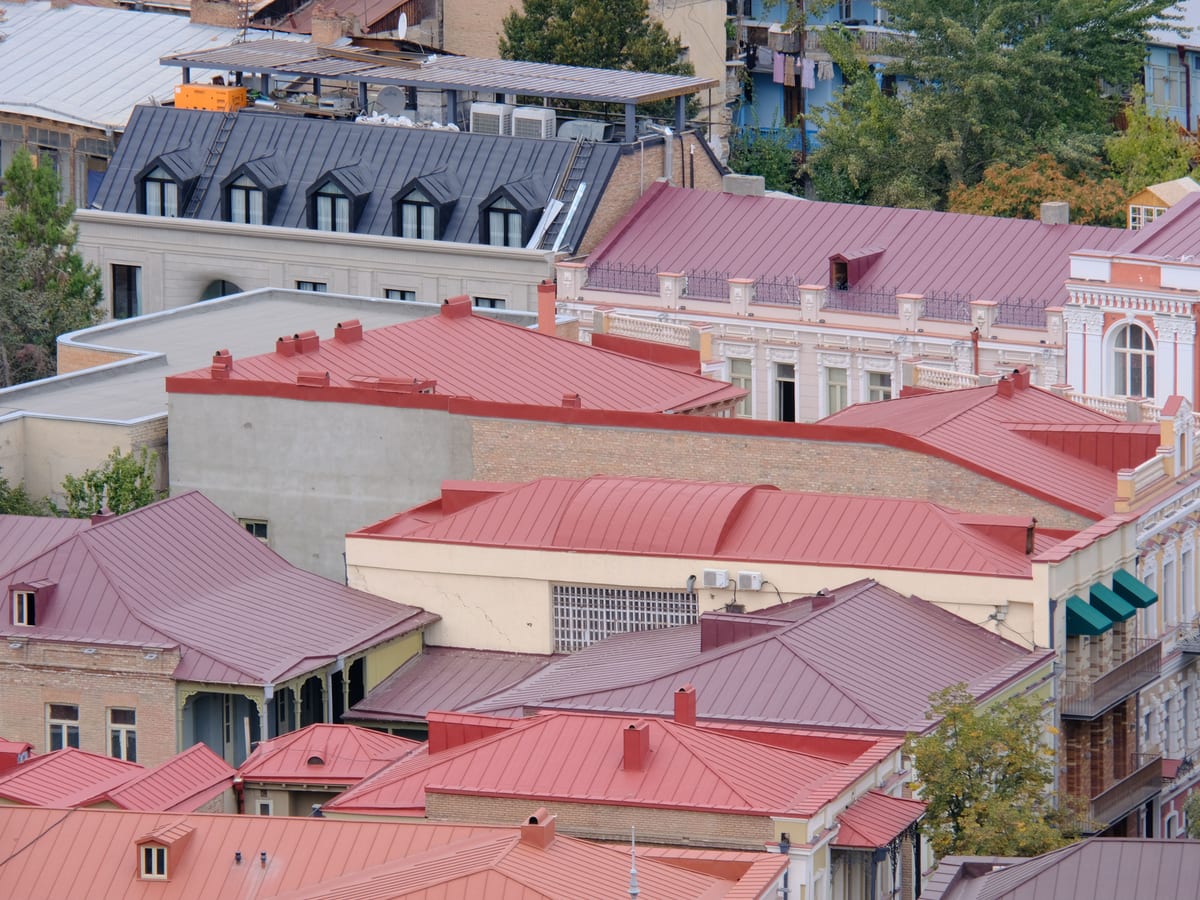 Vibrant aerial view of red rooftops and historic buildings in an urban cityscape.