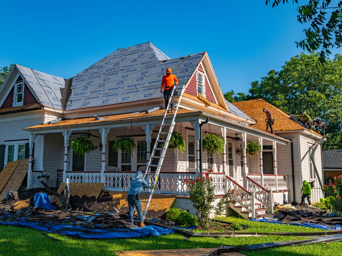 Roofers replace the roof of a historic home in Weatherford, Texas.